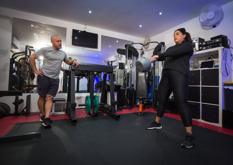 Matt observing a client’s kettlebell exercise during a personal training session